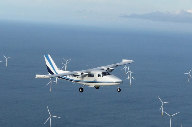 Plane conducting aerial survey over offshore wind farm
