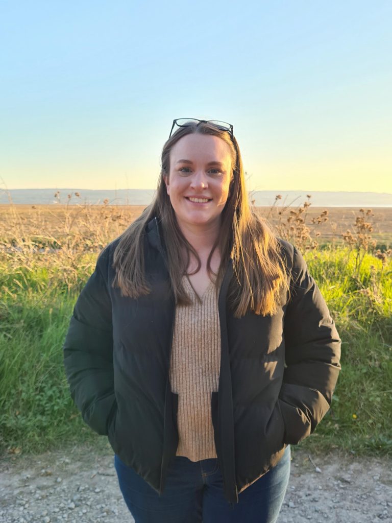 Beth standing in front of a wheat field