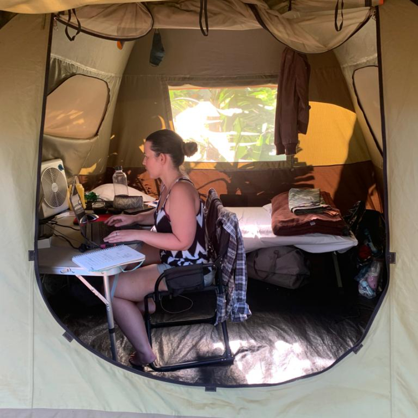 Cassy Flint working at a desk in a tent
