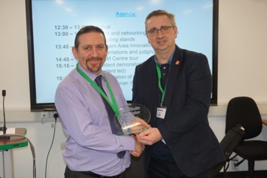 APEM director Dr Stuart Clough shaking hands with Richard Sears, director of communications at Yorkshire Water and holding a glass trophy from the Institute of Water