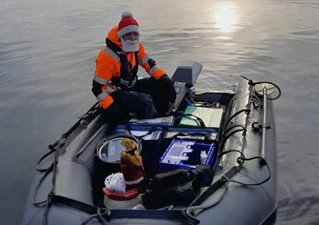 Josh Owen on a boat with a Santa hat on