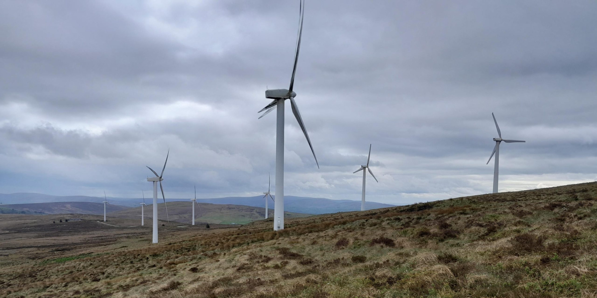 An image of an onshore windfarm on a hill